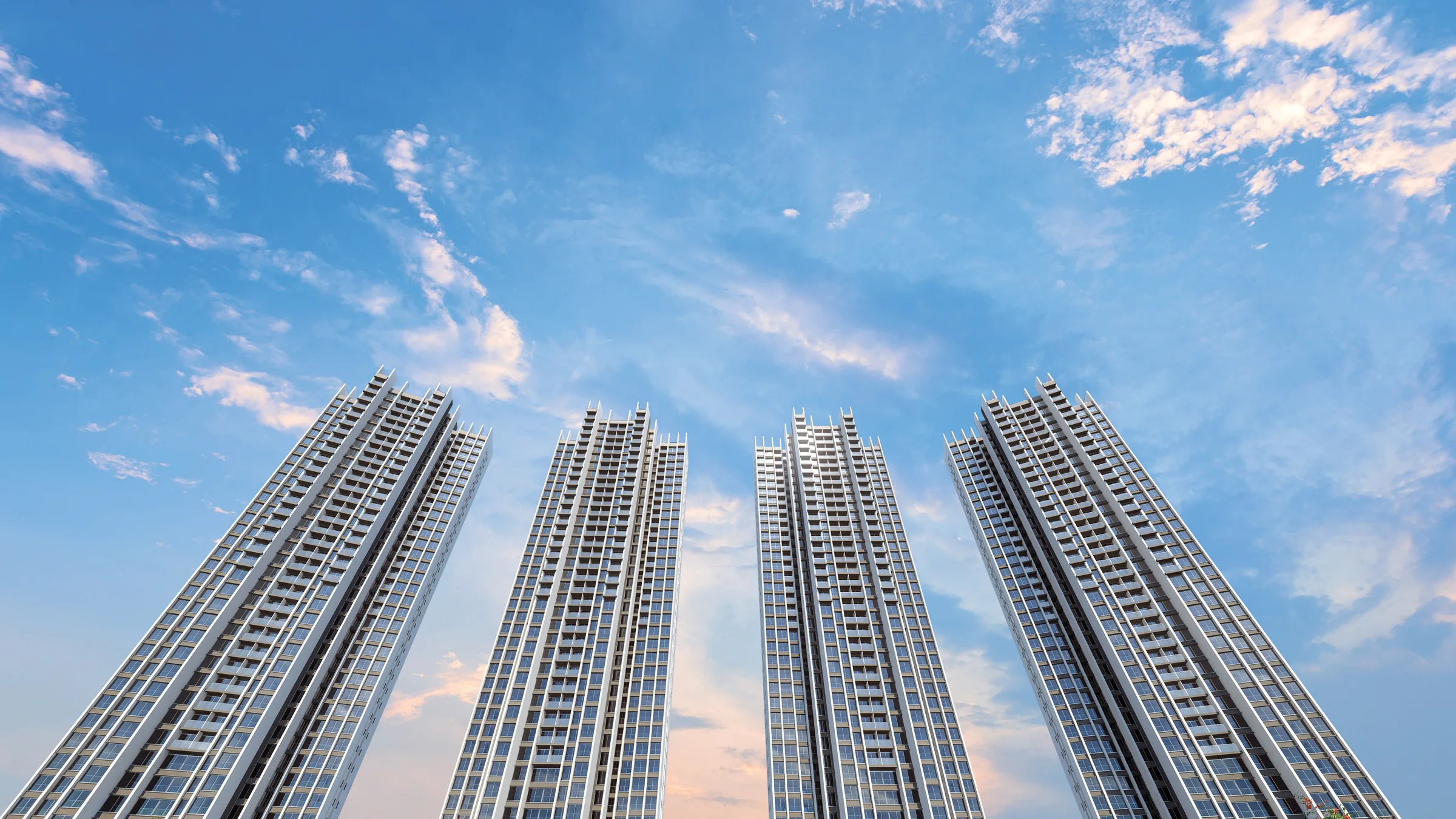 The four towers of Sunteck Sky Park rising against a dusk sky above landscaped grounds